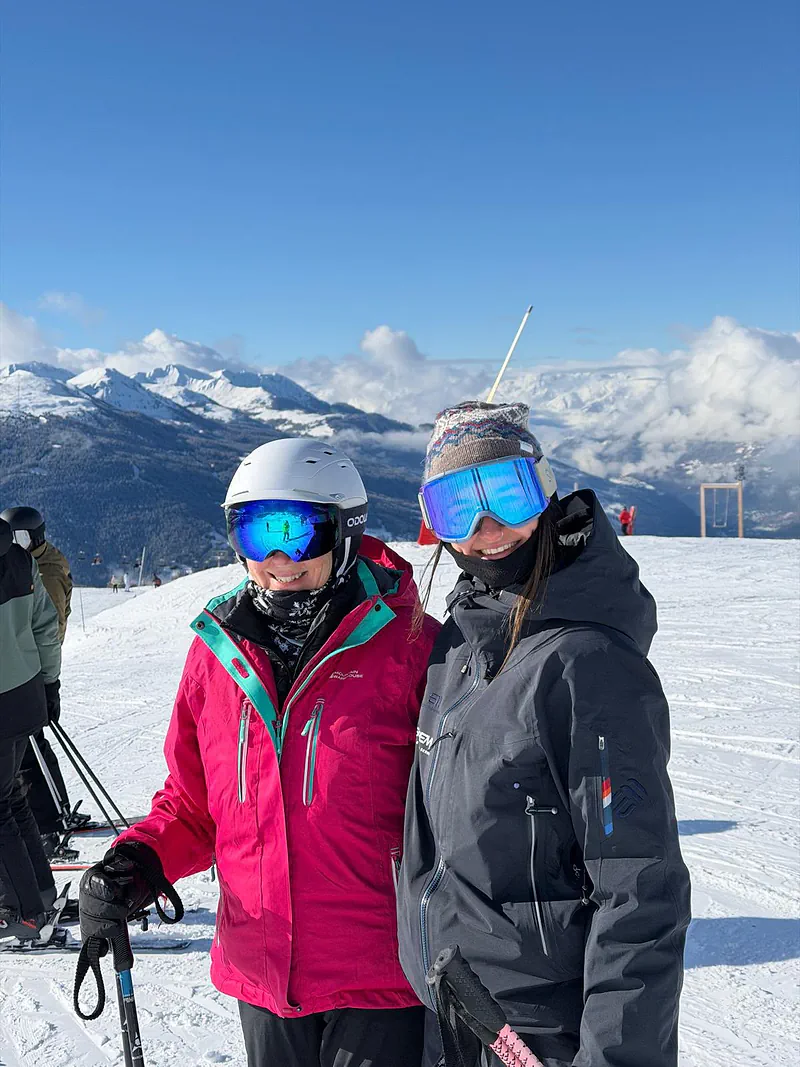 Two skiers posing in front of the peaks