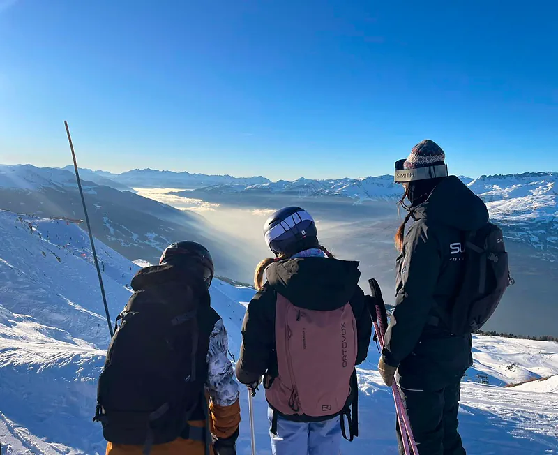 Skiers above a sea of clouds over the Tarentaise valley
